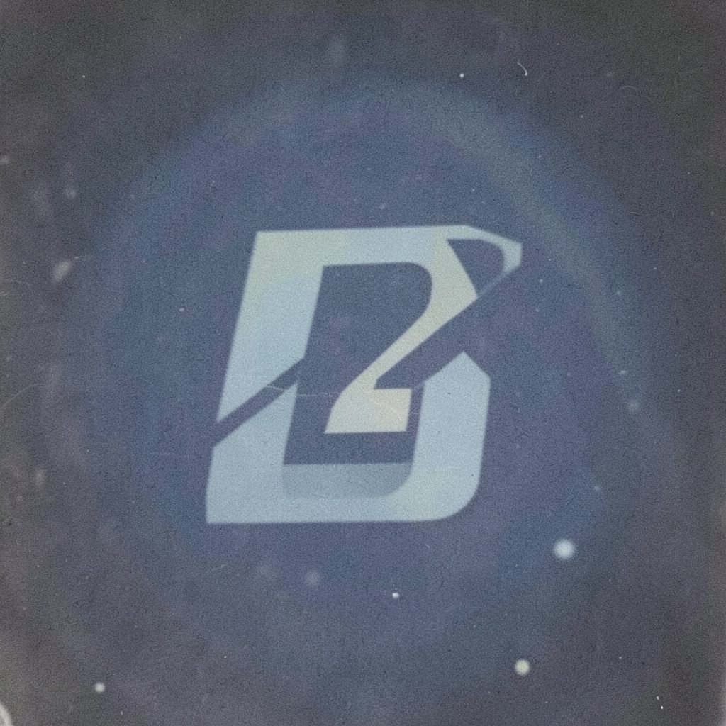 A dark, grainy photograph of an ornate emblem or sigil in deep navy and charcoal tones against a muted background, evoking mystery and esoteric tradition.